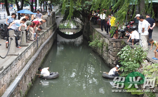 男子坐救生圈钓黄鳝+路人好奇围观